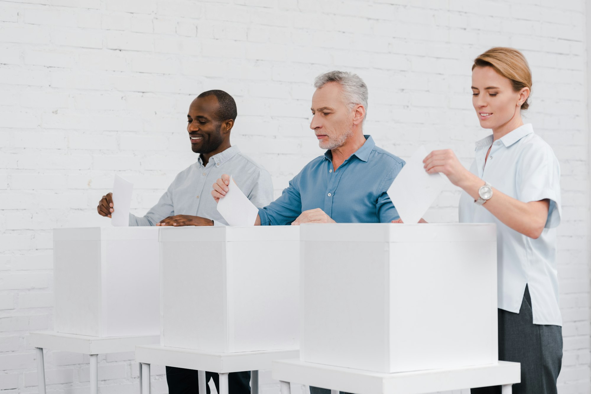 cheerful multicultural citizens voting while standing near boxes