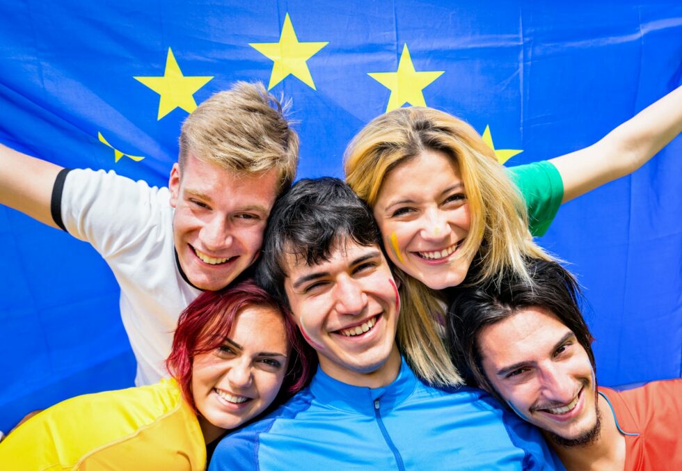 Young football supporter fans cheering with european flag