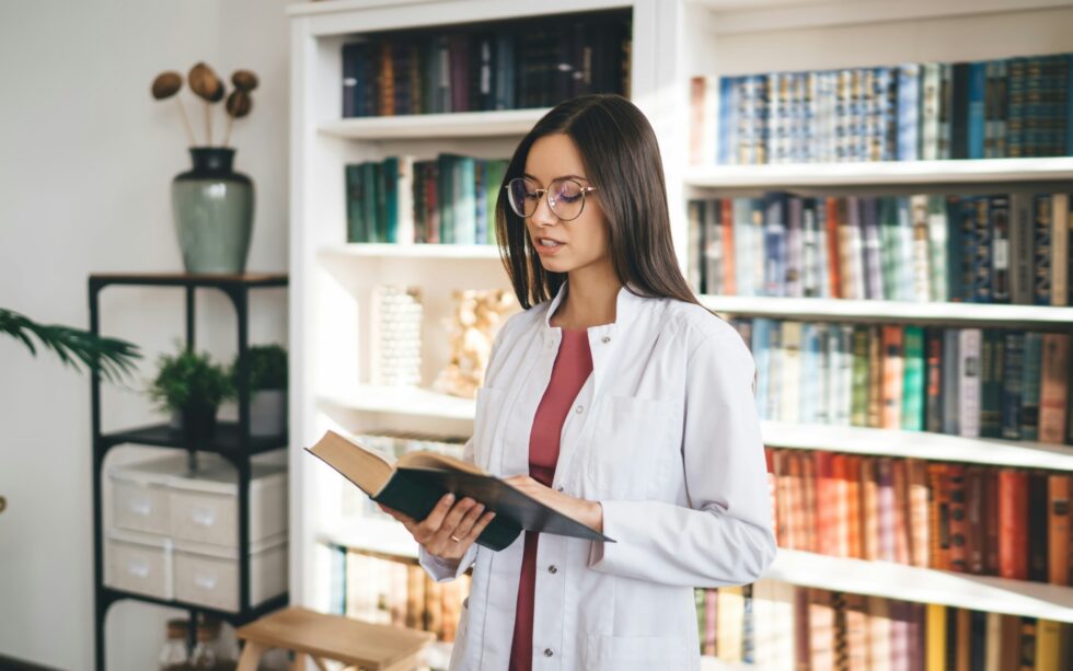 Focused female medical student reading book